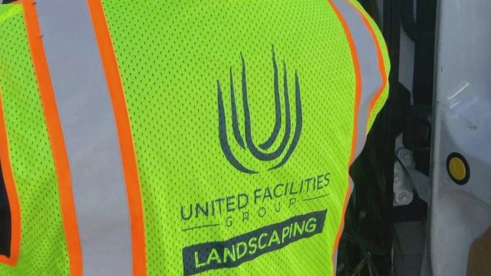 Close-up of a high-visibility UFG Landscaping vest, the opening frame of the film Thirteen Years, Three Titles.
